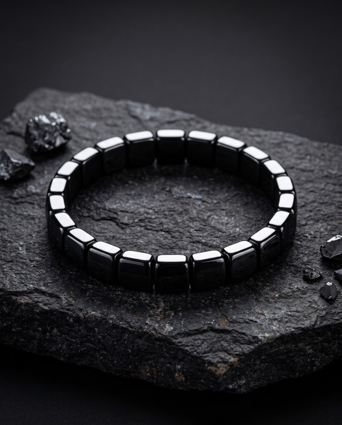 Bracelet en hématite polie posé sur une pierre