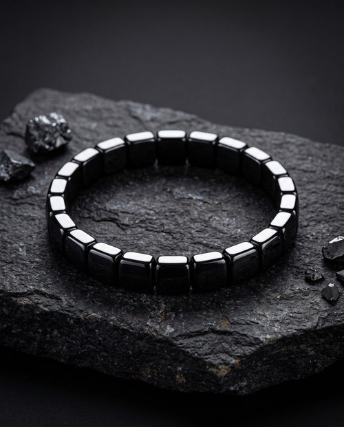 Bracelet en hématite polie posé sur une pierre
