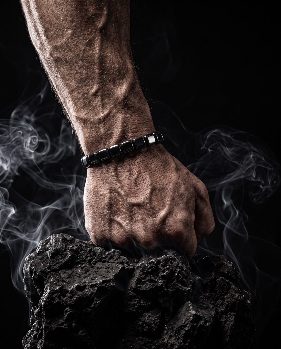Poing fermé portant le bracelet en hématite